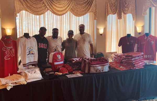 Group of people posing in front of stack of jerseys