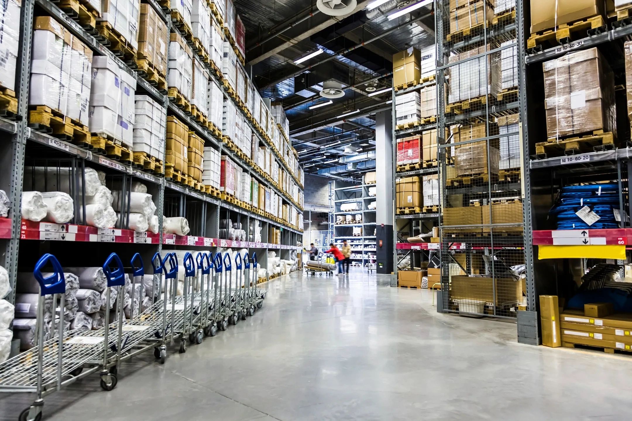 Spacious warehouse with tall shelves and stacked boxes.