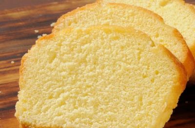 Close-up of three slices of pound cake on a wooden surface.