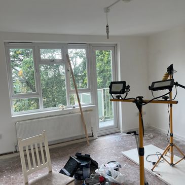 Room under renovation with construction lights and materials.