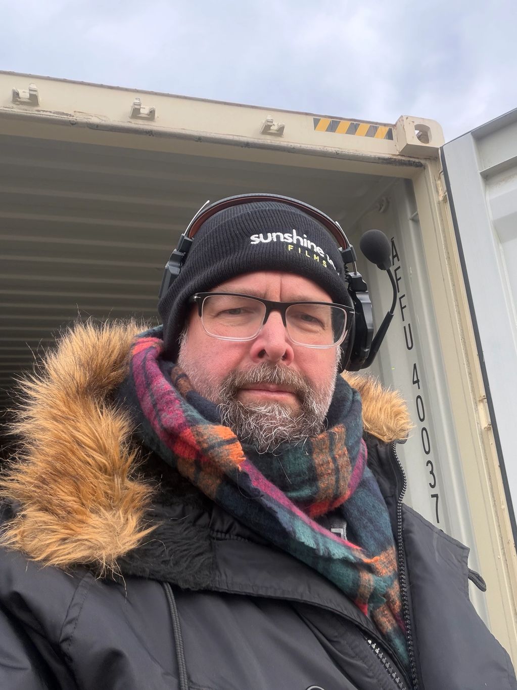 Man in winter clothing and headset taking a selfie.