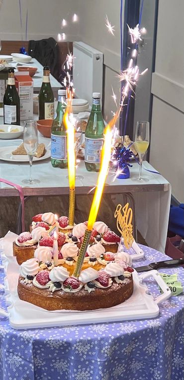 Celebratory cake with sparklers and strawberries on a festive table.