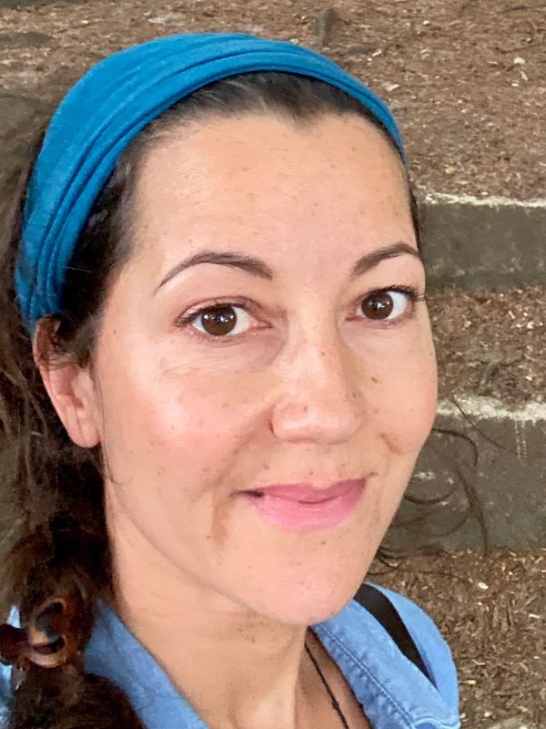 Woman wearing a blue headband smiling.