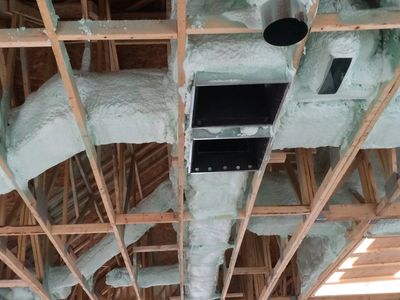 Servant à un système de chauffage à haut rendement, un réseau de conduits dans dans le grenier d'une résidence en rénovation à Montréal