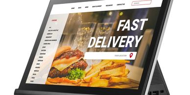 Tablet displaying a fast delivery food ordering website with burger and fries.