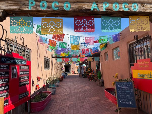 A picture of the street decorated with colorful papel picado banners