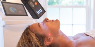 A woman laying down on a bed with a therapy going on