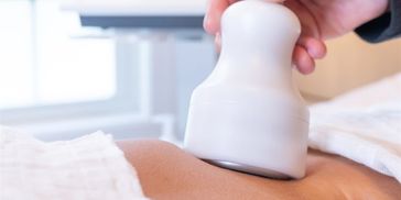 A woman laying down on a bed with a therapy going on