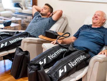 Two people laying on chairs and going through a therapy