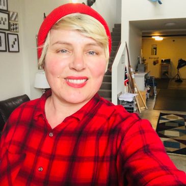 Yolanda, Founder of Yolo Dog Go! smiles while taking a selfie in a red hat.