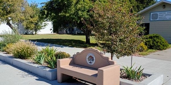 Brown sculpted bench with a circular emblem.