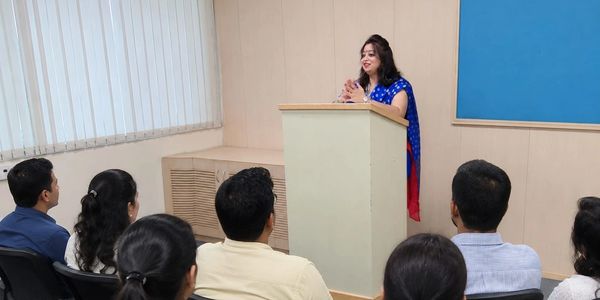 Woman speaking to an audience in a classroom.