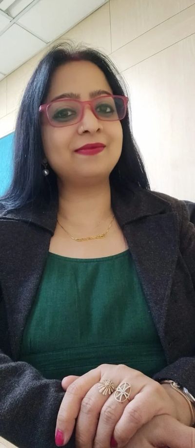 Woman with glasses and rings smiling.