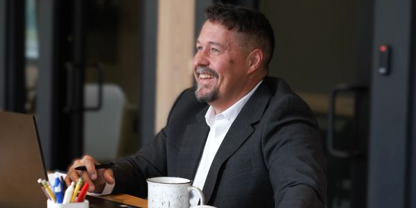 Smiling man in suit working at desk.