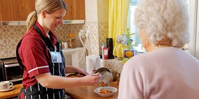 Caregiver preparing food for woman patient