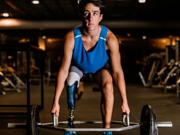Athlete with prosthetic leg lifting weights.