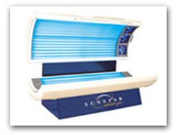 Modern indoor tanning bed with blue UV lights and control panel.