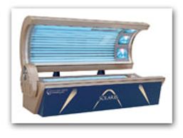 A horizontal tanning bed with blue UV light tubes and control knobs.