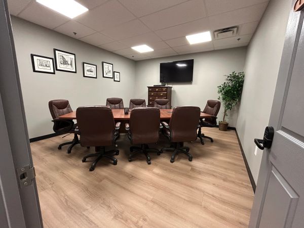 Modern conference room with leather chairs and TV.