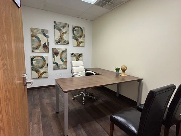 Minimalist office with modern furniture and wall art.
