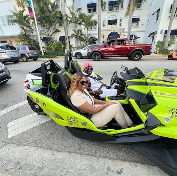 Customers driving a slingshot in Ocean Drive, South Beach