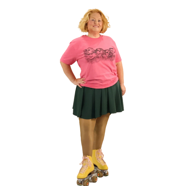 Woman in pink shirt and green skirt wearing yellow roller skates.