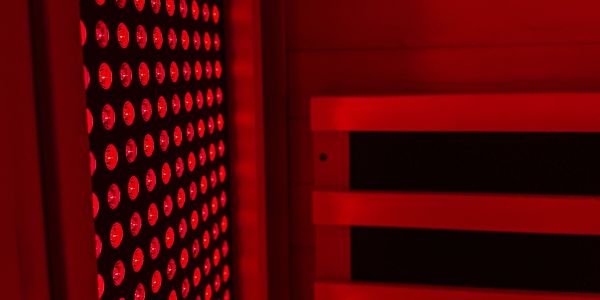Red LED light panel illuminating a dark interior space.