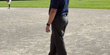 Baseball umpire standing on the field observing the game.