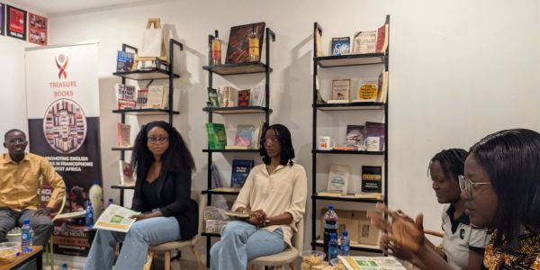 Group discussing books in a cozy room with shelves.