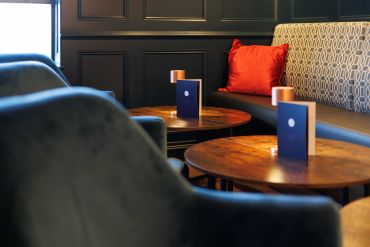Cozy seating area with patterned cushions and wooden tables.