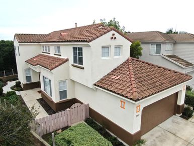 Modern two-story house with tiled roof and attached garage.