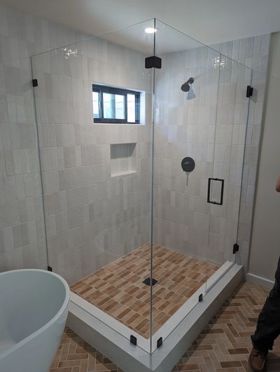 One of our frameless neo-angle shower enclosures with low-iron glass and matte black hardware.