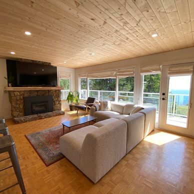 Open layout living room attached to kitchen and dining room overlooking the ocean at the Surf Chalet.