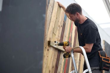 REBUILD events team using drill on trade show wall
