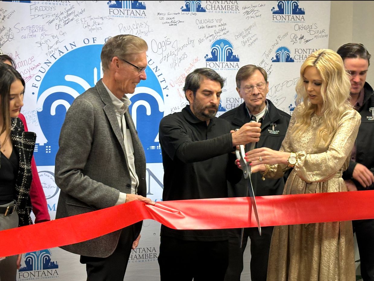 Group cutting a red ribbon at Fontana Chamber event.