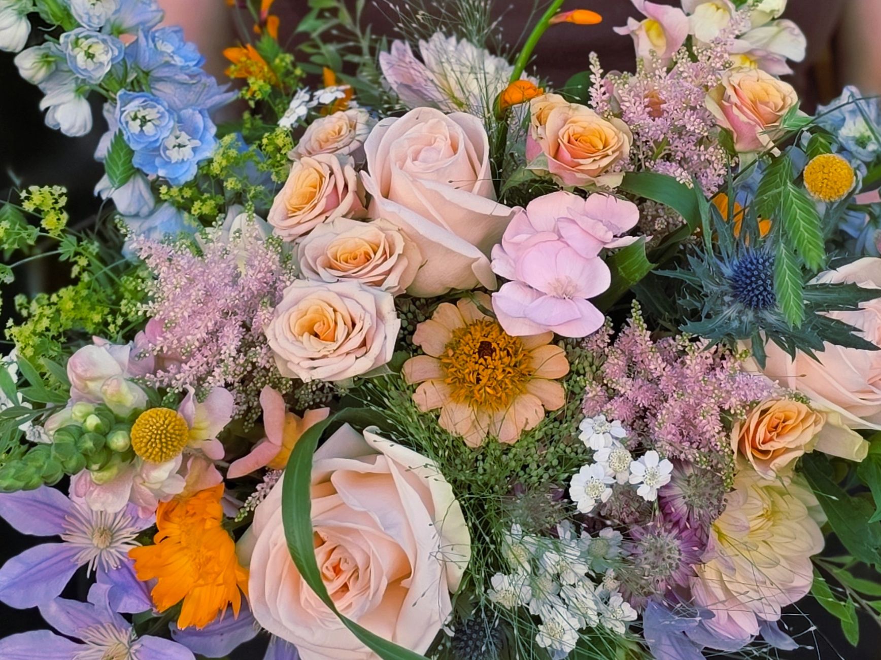 A vibrant bouquet of mixed flowers with pastel roses and wildflowers.