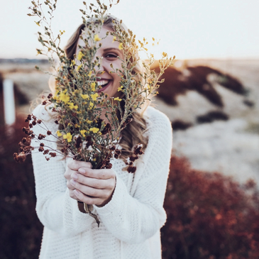 Femme qui souri avec un bouquet de fleurs