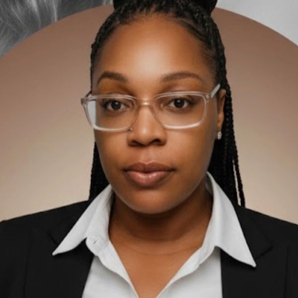 Professional woman with braided hair and glasses in front of a grayscale portrait.