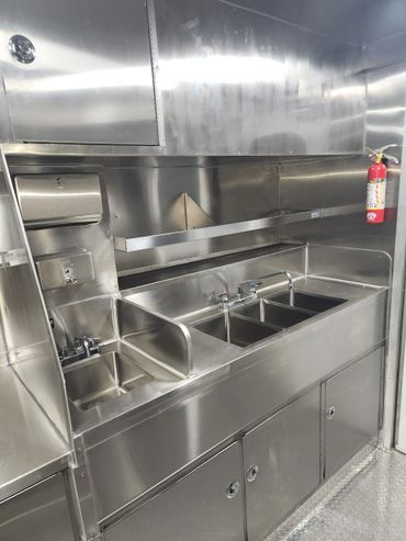 Sleek stainless steel triple sink setup in a commercial kitchen.