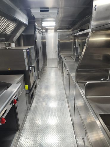 Interior of a clean, stainless steel commercial kitchen.
