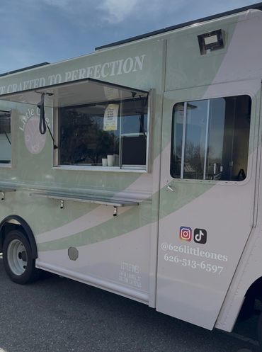 Light green and white food truck named Little Ones with service window.