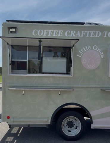 Side view of a coffee food truck named Little Ones with service window open.