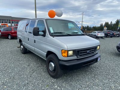 Silver Ford cargo van parked on gravel.
