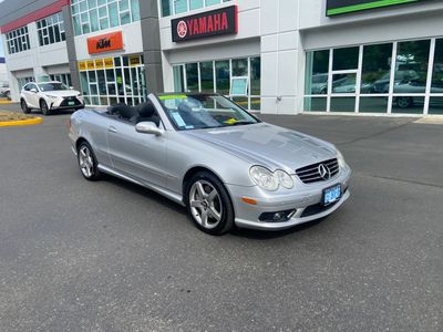 Silver Mercedes convertible parked outside a dealership.