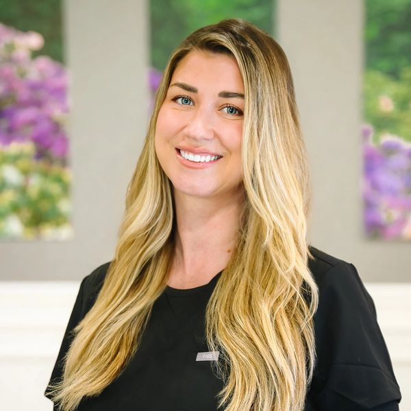 Smiling woman with long blonde hair in a black shirt.