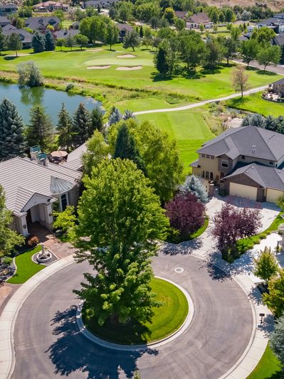 A peaceful suburban cul-de-sac with lush greenery and a golf course nearby.