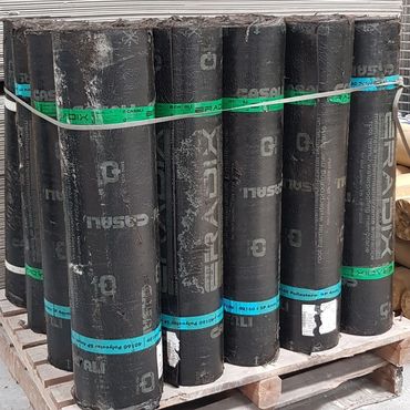 Rolls of black waterproofing membrane stacked on a wooden pallet.