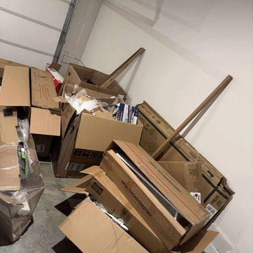 Stack of opened cardboard boxes in a garage corner.