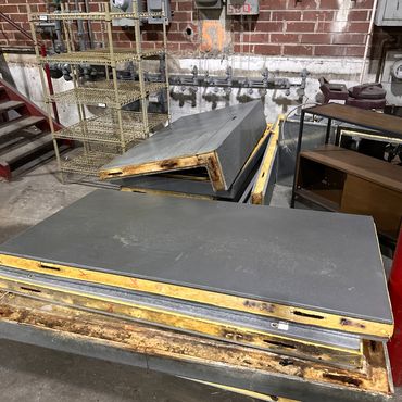Stack of disassembled industrial insulated metal panels in a warehouse.