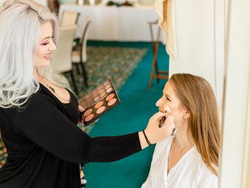Makeup artist applying makeup on a woman.